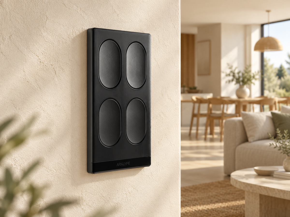 Non-illuminated four-button StellarTrack switch on a wall beside a warm living and dining space.