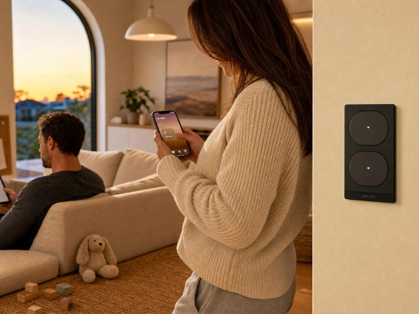 An Australian family at home at dusk - woman with smartphone using Apple Home, partner on sofa with iPad, child's toys on floor, StellarTrack Matter over Thread switch on wall.
